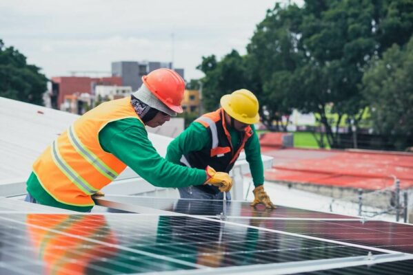 Hombres colocando paneles fotovoltaicos
